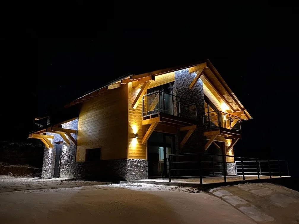 Chalet Filipsky Deluxe v noci, osvetlená drevená a kamenná fasáda